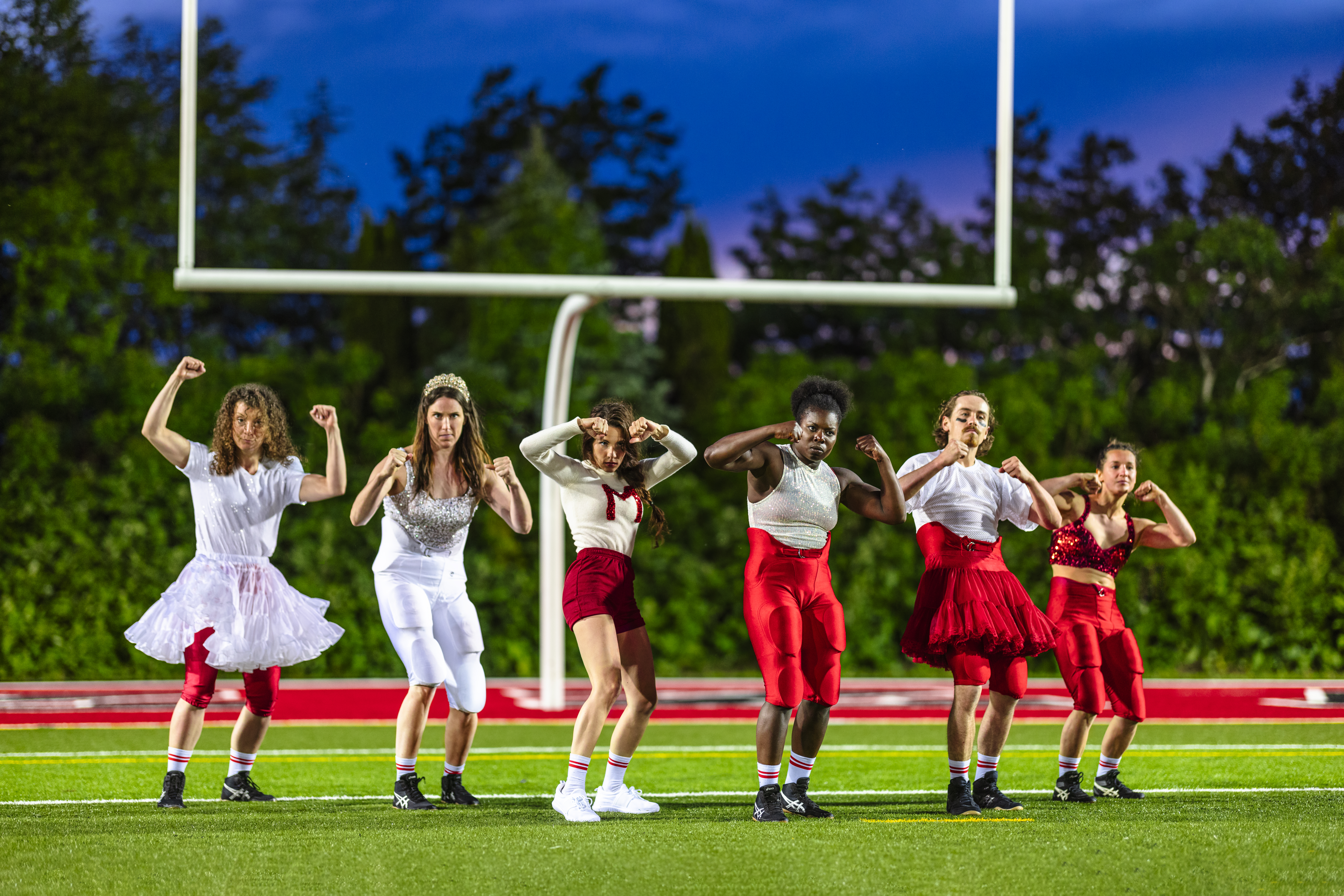 The members of Flip Fabrique pose on a football field