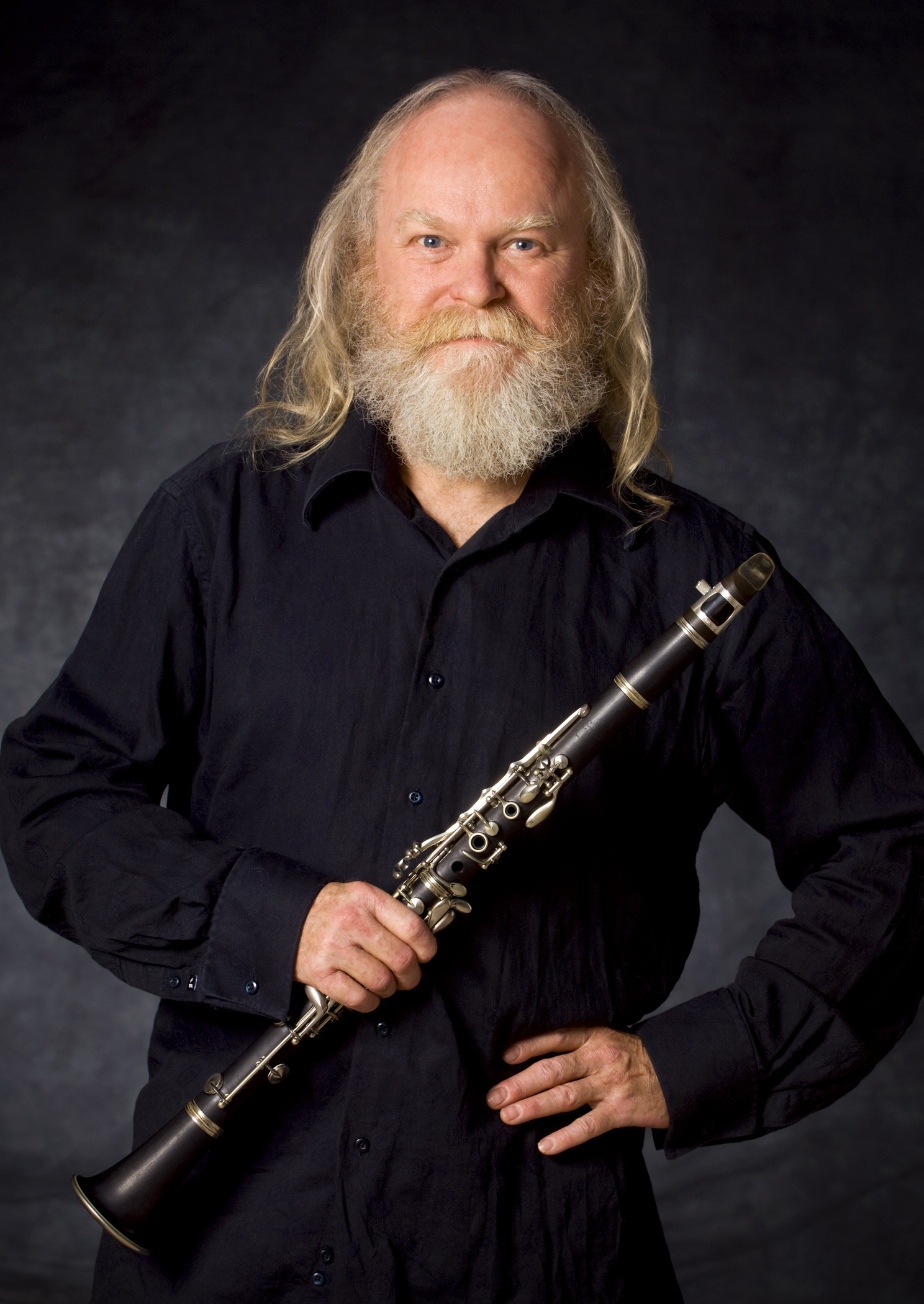 Richard Hornsby wearing all black, facing the camera and holding a clarinet