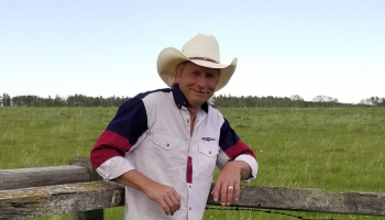Man leaning on a fence