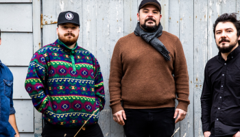 4 members of Silver Wolf Band in front of a barn wall