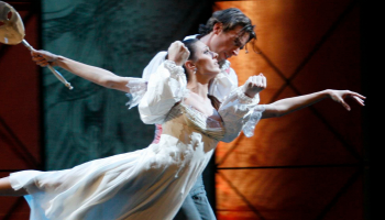 A man and a woman in ballet attire, looking intense.
