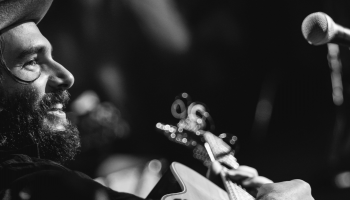 A profile view of a man playing guitar with a microphone in front of him