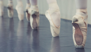 The feet of ballerinas on pointe. Neutral colors.