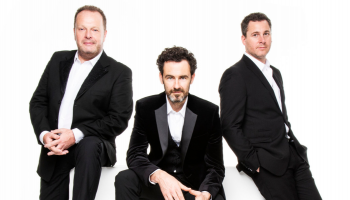 3 members of The Celtic Tenors in black suits against a white background