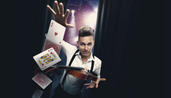 Chris Funk is centered on a dark background with the image of a violin in one hand and playing cards floating in the air under his other hand. 