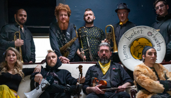 10 members of the band Lemon Bucket Orkestra facing the camera, holding their instruments