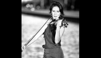 A black and white image of a person playing the violin.