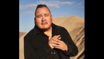 A portrait of William Prince standing in front of a mountain.
