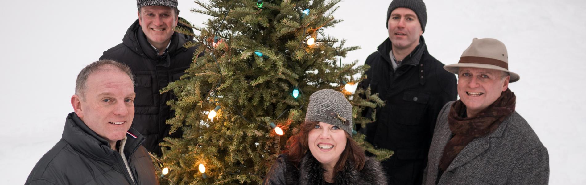 Barra MacNeils standing around a Christmas tree.