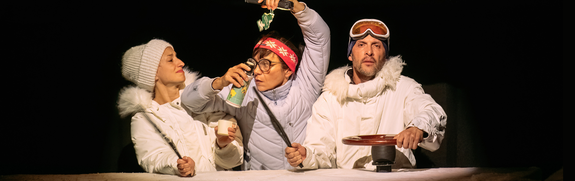 Three actors dressed as researchers in white parkas against a black background