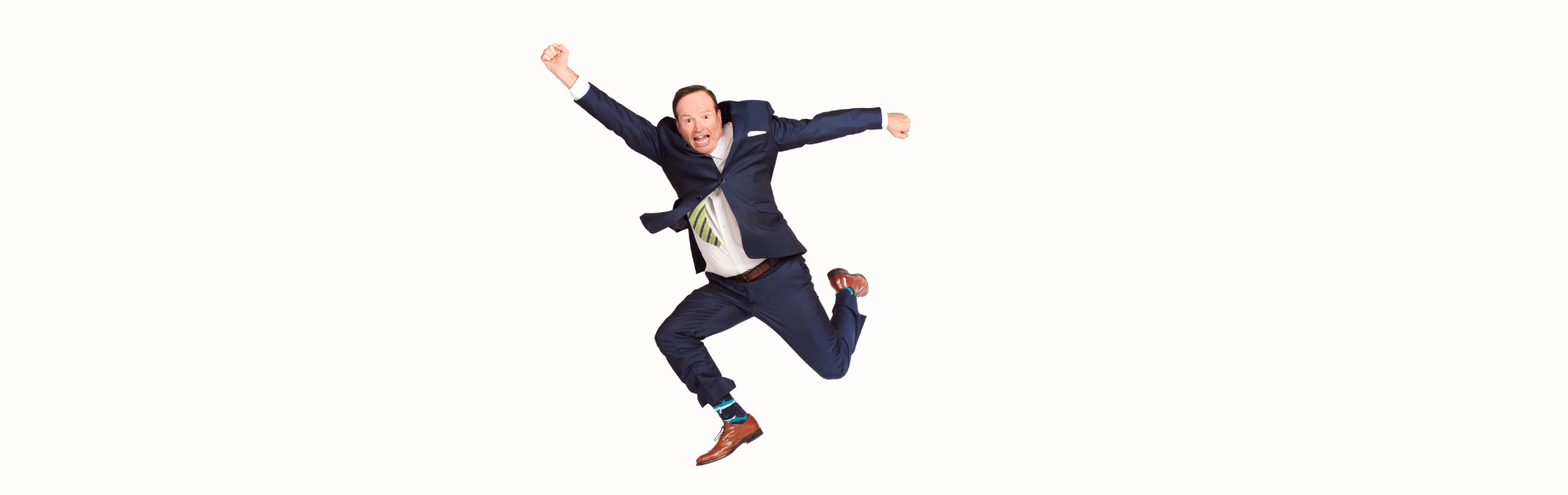 Steve Patterson jumping in the air, arms outstretched at different angles, and legs bent. He's wearing a full suit and is in front of a flat white background