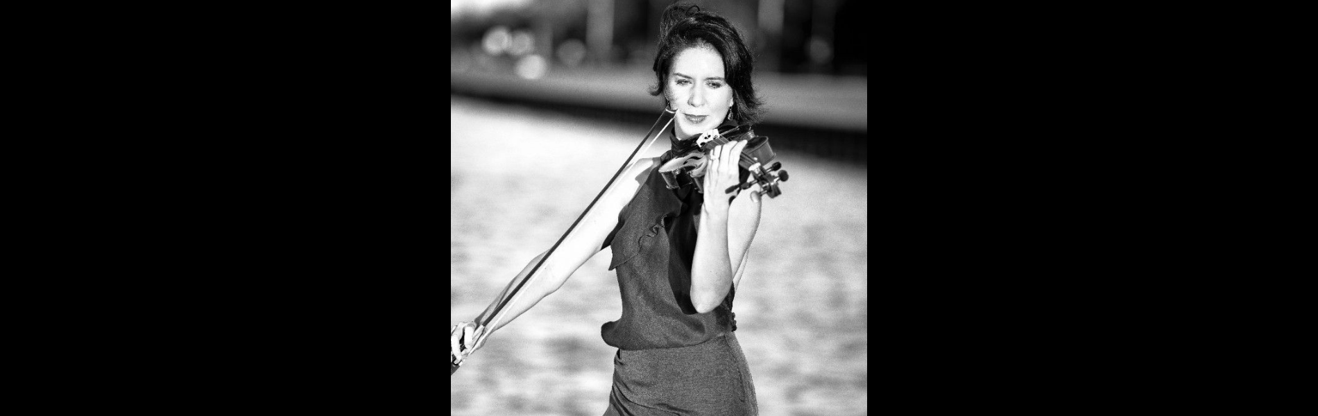 A black and white image of a person playing the violin.