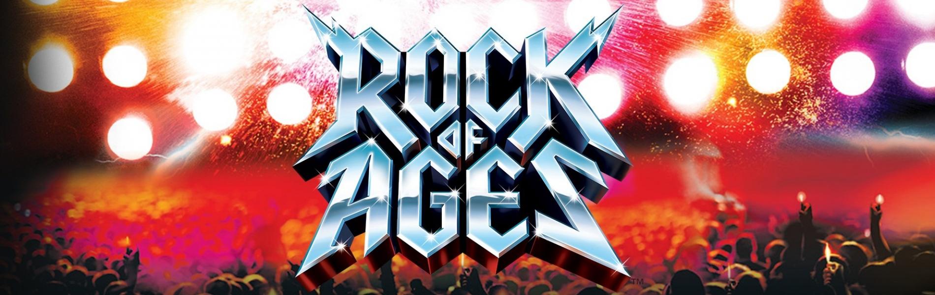 The words, 'Rock of Ages' in large silver lettering with bright lights shining behind them.