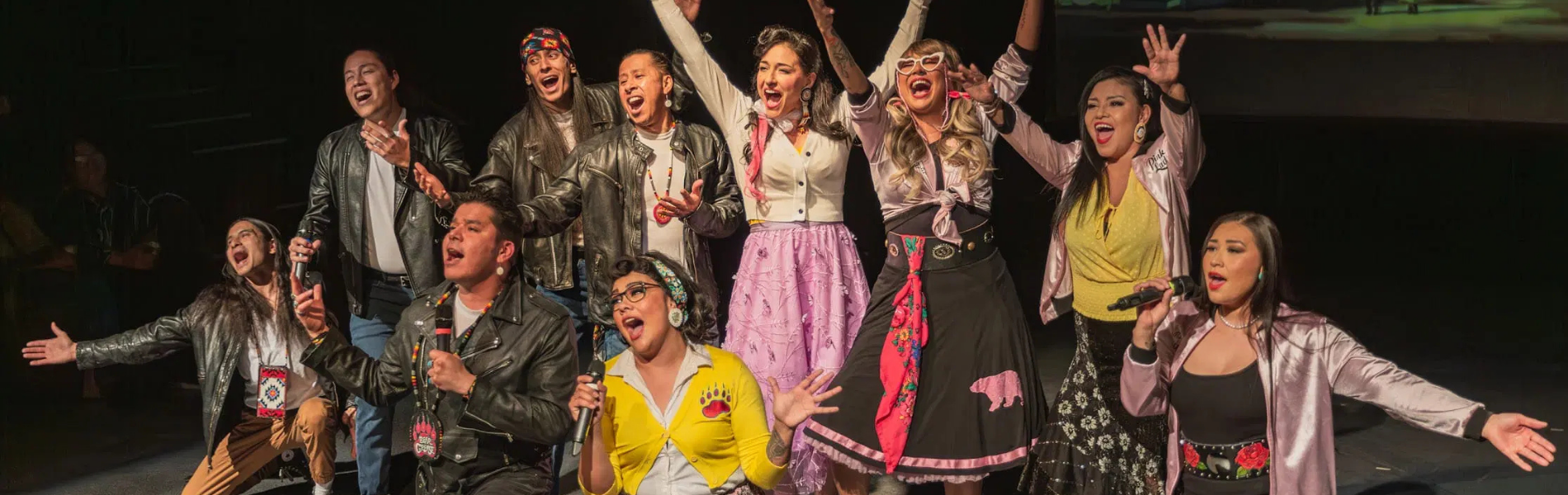 The cast of Bear Grease the Musical strike poses on a city street. 