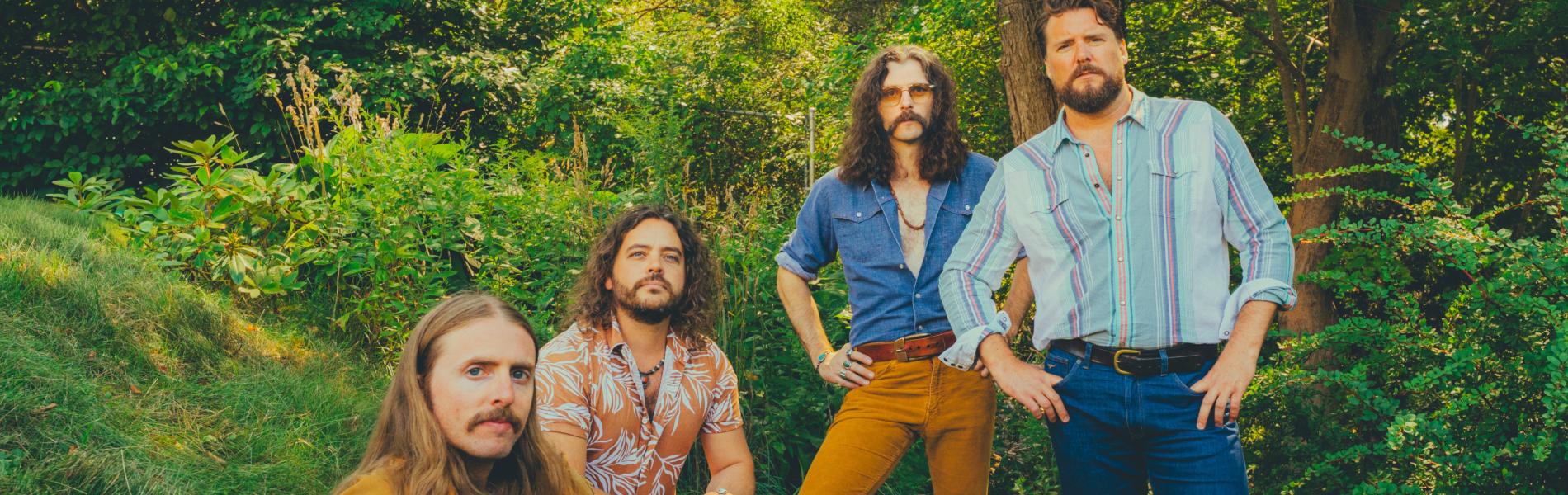 The Sheepdogs band members in a green forest
