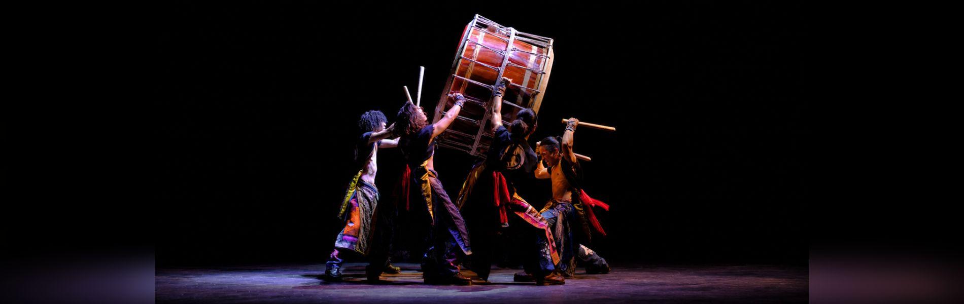 Members of Yamato Drummers hold up a large drum