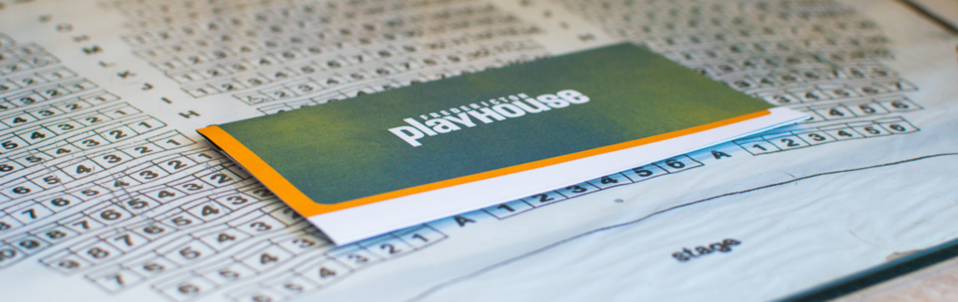 A Playhouse ticket envelope lays on a flat surface