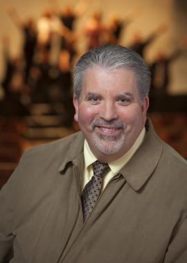 Headshot of Philip Sexsmith wearing a light brown jacket